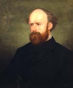 Balding white man with a red beard wearing a black coat and vest adorned with a watch fob.